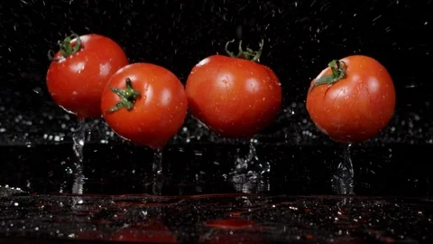 Tomatoes falling and splashing on black background 動画素材 89340714