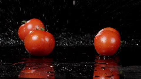 Tomatoes falling and splashing on black background 動画素材 89342345
