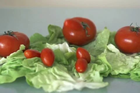 Tomatoes falling on lettuce leafs, slow motion shot at 480fps NTSC Video stock 12369852