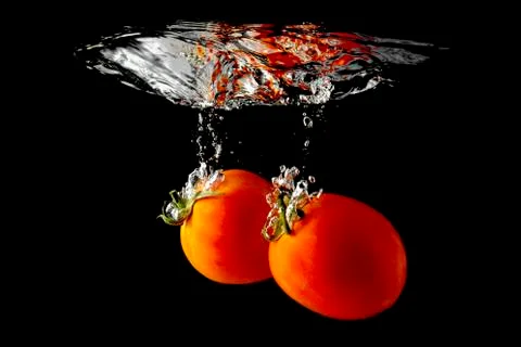 Tomatoes falling through water Stock Photos