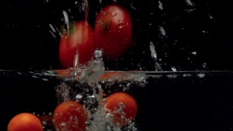 Tomatoes falling into the water Stock Footage 123703973
