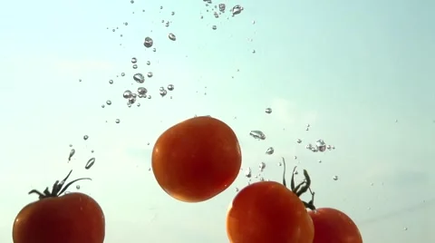 Tomatoes falling into water. Slow motion 240 fps. Video stock 55299033