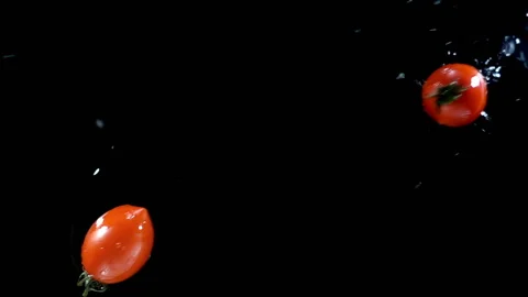Tomatoes falling into water in slow motion Stock Footage 153094803