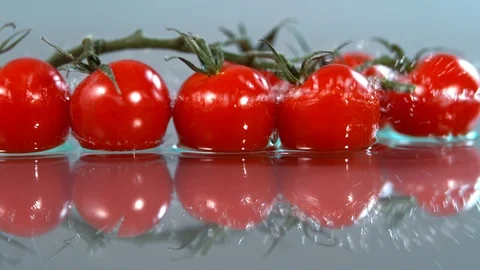 Tomatoes falling to water in super slow motion, shot with high speed cinema Stock Footage 101284170