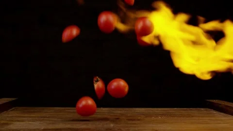Tomatoes in fire. Vegetables throwing falling through fire Stock Footage 259597790
