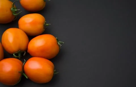 Tomatoes flat lay on black background. Stock Photos