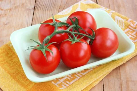 The tomatoes in the foam tray on the table. Stock-Fotos