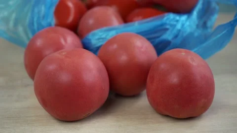 Tomatoes lying on a wooden table Stock Footage 158420490