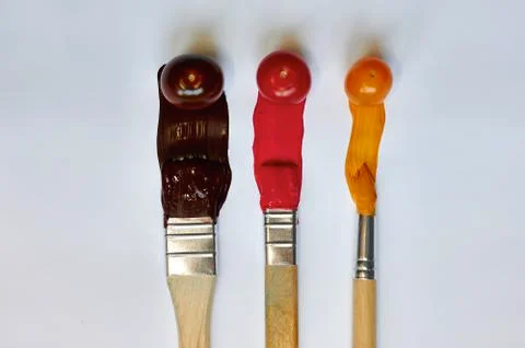 Tomatoes with paint on a white background Stock Photos