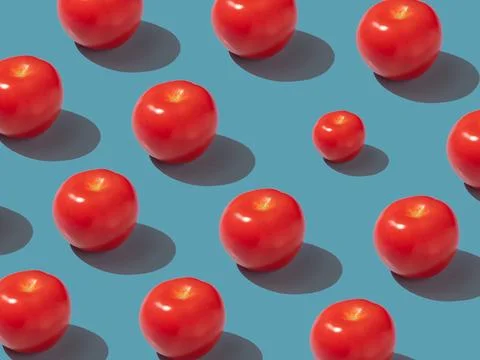 Tomatoes pattern photo with hard shadows in blue background 스톡 사진