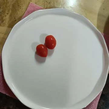Tomatoes on plate Stock Photos