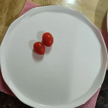 Tomatoes on plate Stock Photos