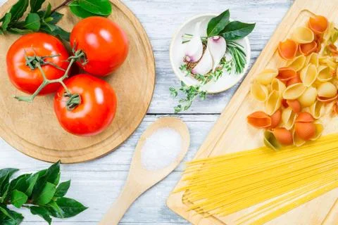 Tomatoes, spicies and uncooked assorted pasta Stock Photos