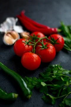 Tomatoes with vegetables on a dark background Stock Photos