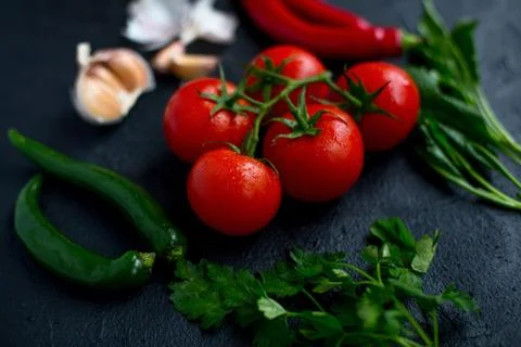 Tomatoes with vegetables on a dark background Stock Photos