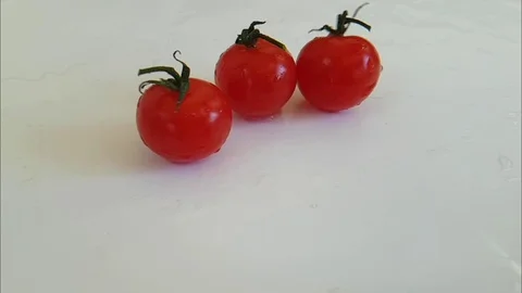 Tomatoes wet on a white background spinning Stock Footage 87655704