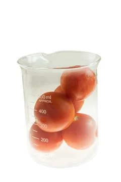 Tomatos in beaker Stock Photos