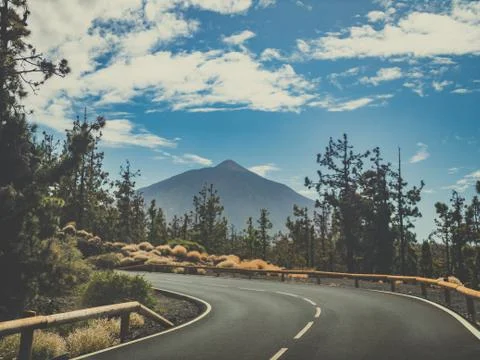 Toned image of sharp road turn in mountains and amazing view on volcano Teide Stock Photos