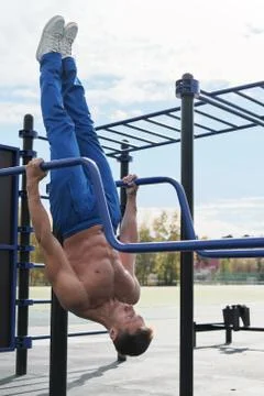 Toned man workout on parallel bars. Stock Photos