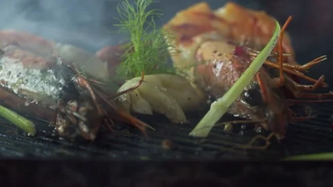 Tongs flips the prawns that are grilled with herbs and garlic Stock Footage 131232653