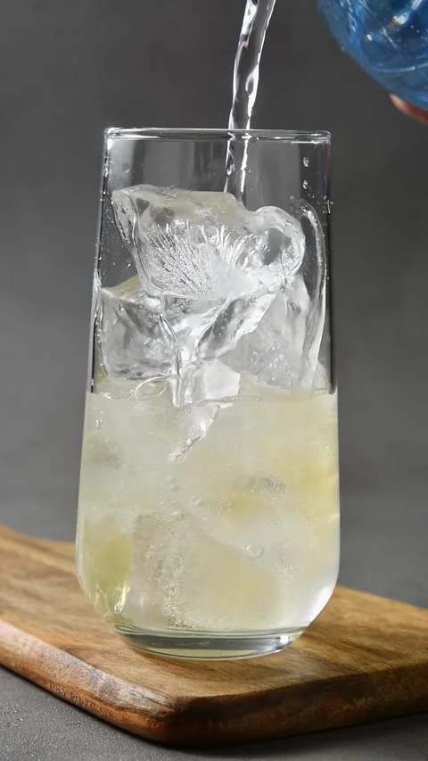 Tonic pours over ice and apple cider in glass, creating fizzy base for cold brew Stock Footage 345486895