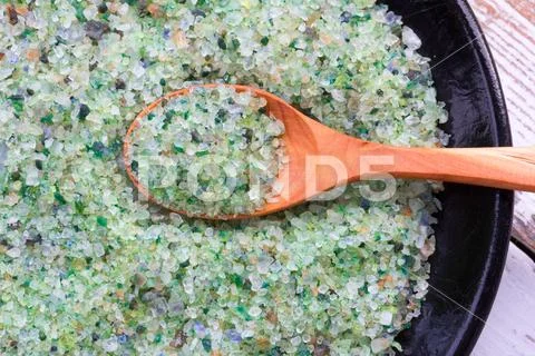 A tonic for the skin sea salt with pine concentrate in wooden spoon on black Stock Photos