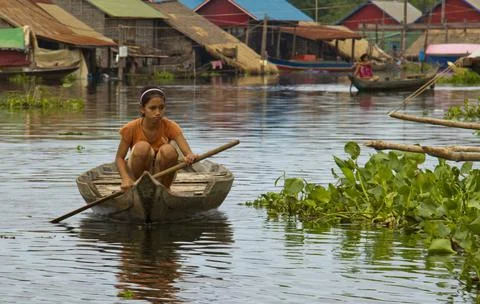 Tonle Sap Lake, Cambodia - Oct 14, 2011: Girl rowing her boat Stock Photos