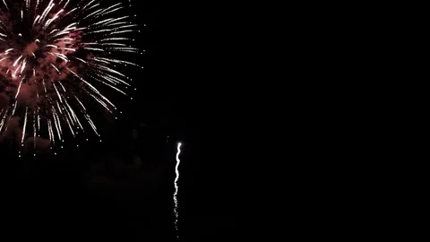 Tons of fireworks go off in sky in front of teen Stock Footage 80800596
