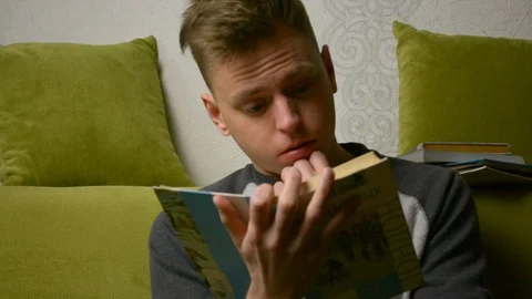 Too excited and intrested while reading teeanger young man 库存影片 92991302