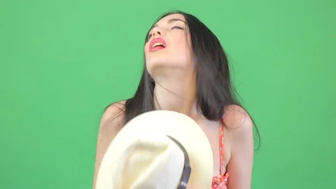 Too hot weather. Model posing in bikini over green screen. Hat in hand, summer Stock Footage 96312028