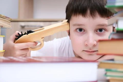 Too much information concept, a boy kid sitting at the desk and holding a toy Stock Photos