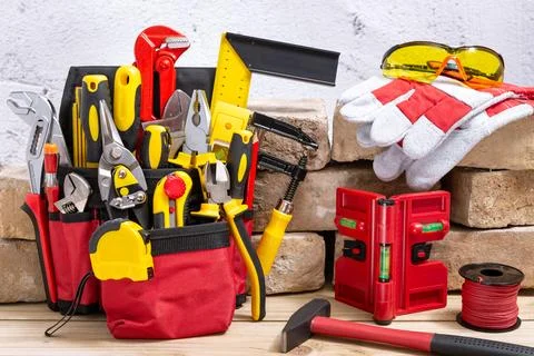 Tool belt with tools next to old bricks Stock Photos