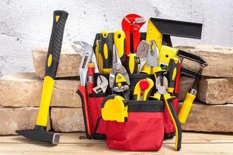 Tool belt with tools next to old bricks Foto stock