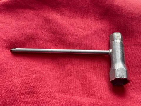 Tool for removing screws on a red cloth background in a workshop setting Stock Photos