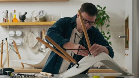 Tool, Studying instructions for furniture assembly by assembling a chair In Stock Footage 241727704