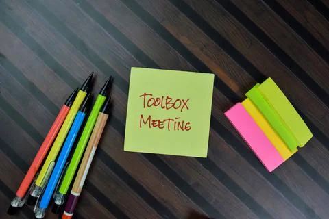 Toolbox Meeting write on sticky notes isolated on Wooden Table. Foto stock