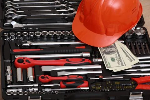 Toolbox, tools kit detail, dollar bills and orange protective helmet close up Stock Photos
