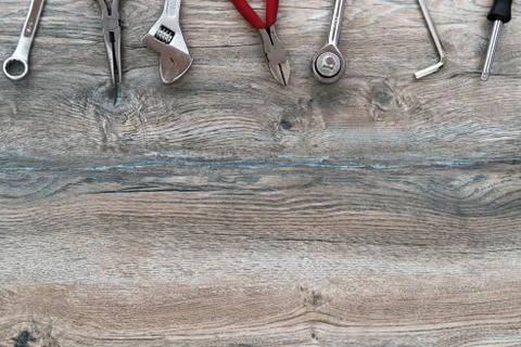 Tools, adjustable wrench, socket wrench, pliers on wood background, top view, Stock Photos