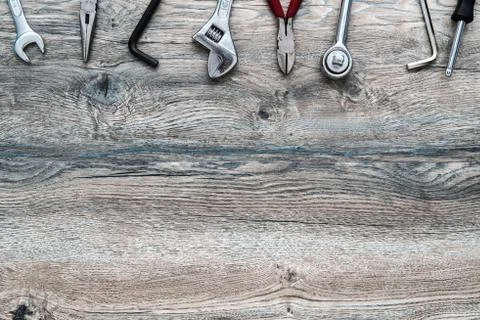 Tools, adjustable wrench, socket wrench, pliers on wood background, top view, Foto stock