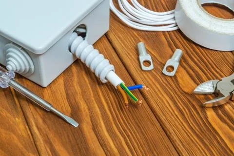 Tools and accessories used in electrical installation or repair on a wooden Stock Photos