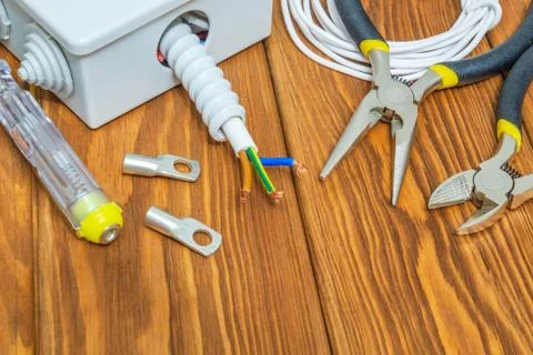 Tools and accessories used in electrical installation or repair on a wooden w Stock Photos