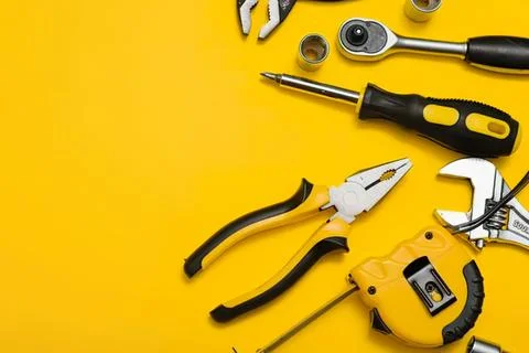 Tools and equipment on yellow background for repair work Stock Photos