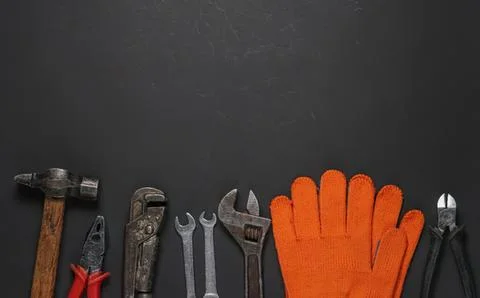 Tools and gloves for handyman work on dark background Stock Photos