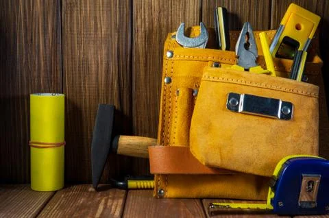 Tools and instruments in leather bag isolated on wooden background. Stock Photos