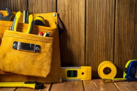 Tools and instruments in leather bag on wooden background. Stock Photos