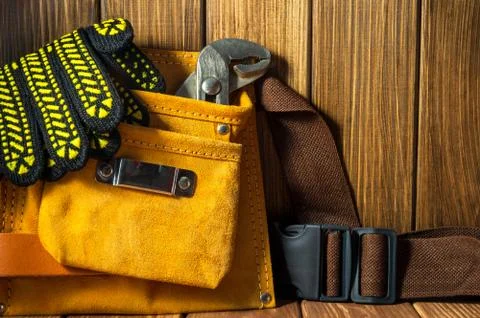 Tools and instruments in leather bag on wooden background. Stock Photos
