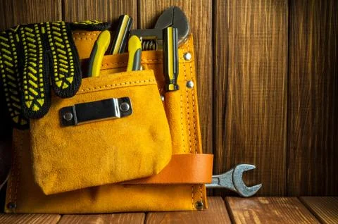 Tools and instruments in a leather bag on vintage wooden boards Stock Photos