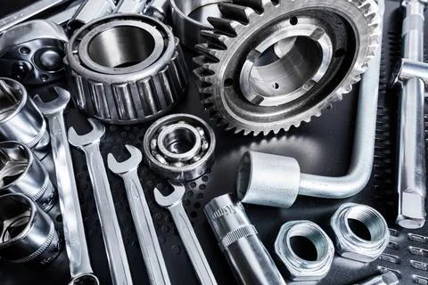 Tools and mechanical components arranged on a black surface with dramatic Stock Photos