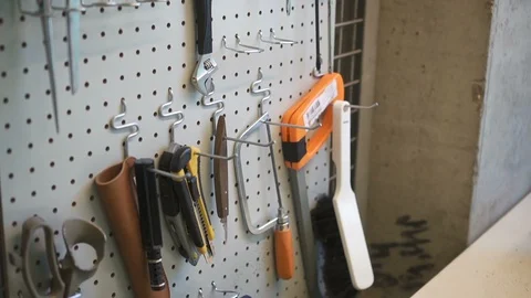 Tools and sewing items hanging on wall in leather workshop. Stock Footage 120409187