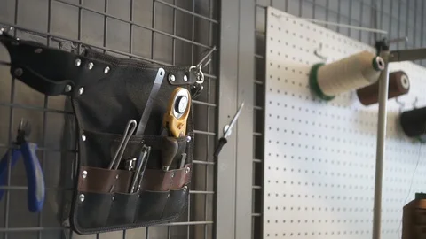 Tools and sewing items hanging on wall in leather workshop studio, instruments Video stock 121389717